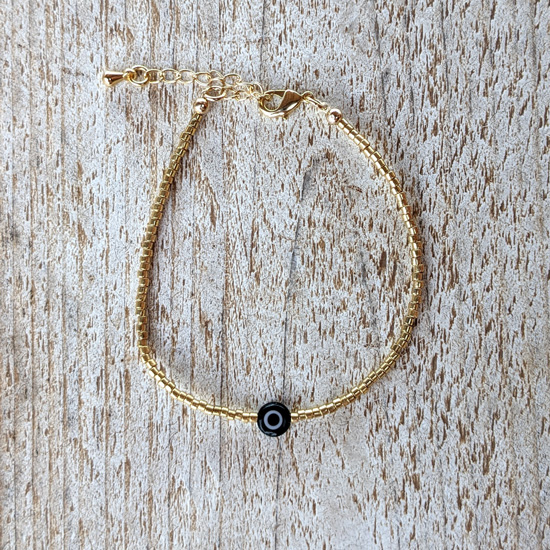 Bracelet Golden Hour (bracelet fin doré avec mauvais oeil noir), créations de la marque Maia et Zoé